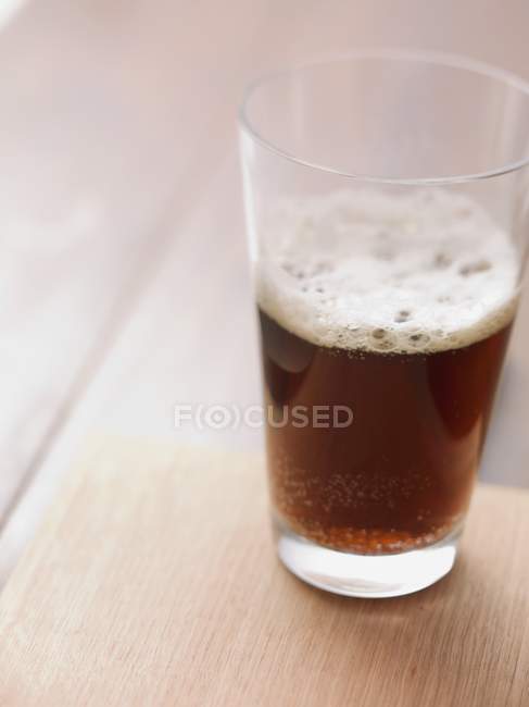 Темное пиво на столе — стоковое фото