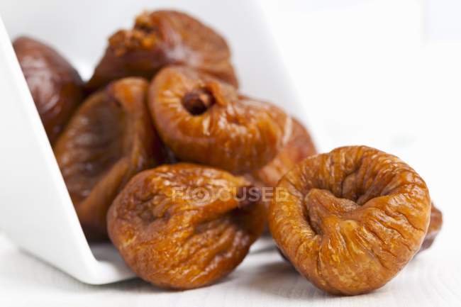 Dried figs falling out of bowl — Stock Photo