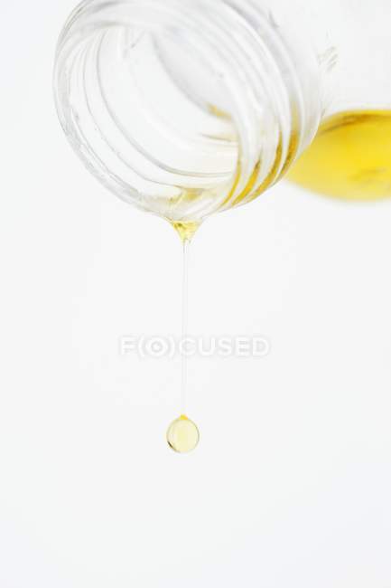 Aceite de oliva que gotea de una botella - foto de stock