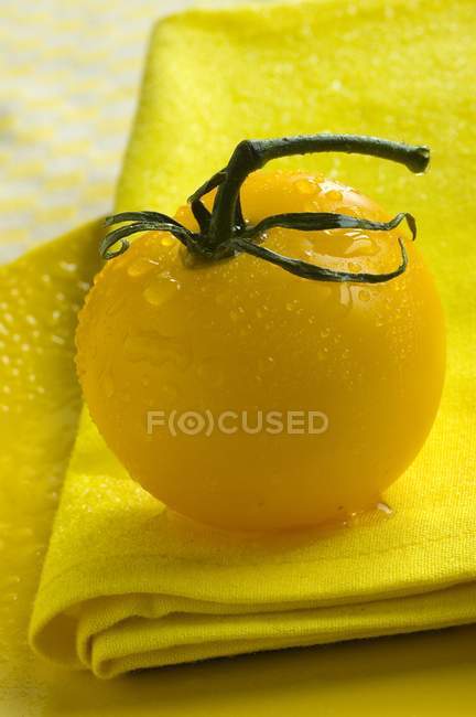 Tomate amarelo com gotas de água — Fotografia de Stock