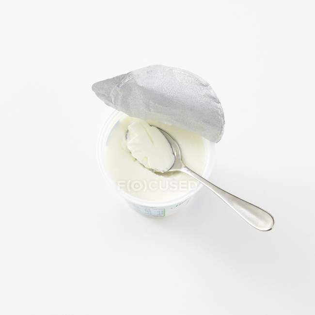 Vista de cerca de la crema agria en taza de plástico con cuchara - foto de stock