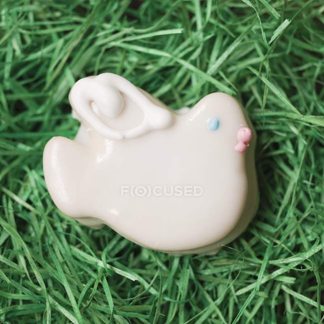 Vue rapprochée d'un poussin de Pâques glacé sur l'herbe — Photo de stock