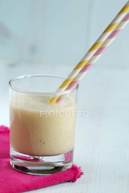 Banana smoothie with straw — Stock Photo