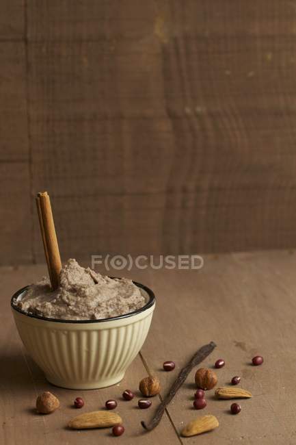 Sweet bean cream with vanilla and cinnamon over wooden surface — Stock Photo