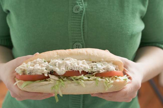 Vue recadrée de la femme tenant un gros sandwich avec salade de poulet — Photo de stock