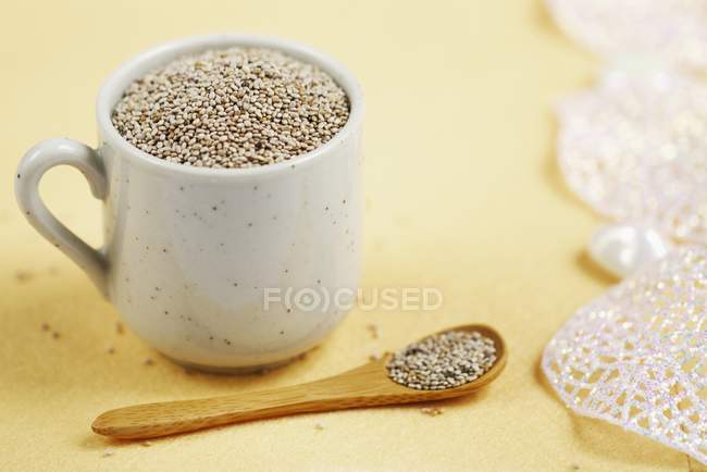 Vista close-up de sementes de chia no copo e na colher — Fotografia de Stock