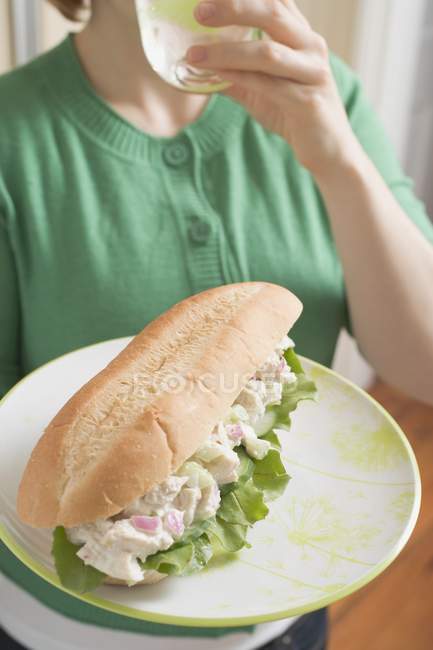 Mulher segurando sanduíche de atum — Fotografia de Stock