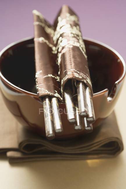 Vue rapprochée de bol de laque avec baguettes sur tissu brun — Photo de stock