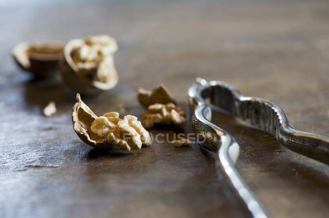 Cracked walnuts and a nutcracker — Stock Photo