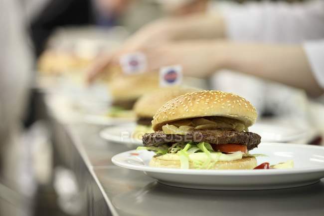 Vista close-up de hambúrgueres linha em uma cozinha comercial — Fotografia de Stock