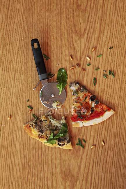Pizza and a pizza wheel — Stock Photo