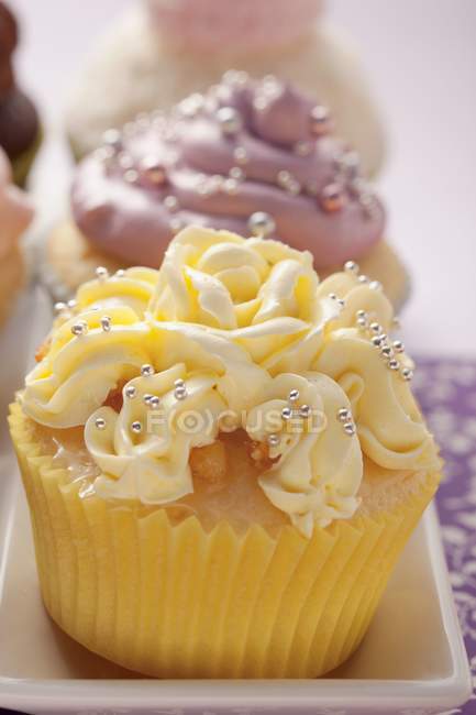 Cupcakes em uma fileira com cobertura — Fotografia de Stock