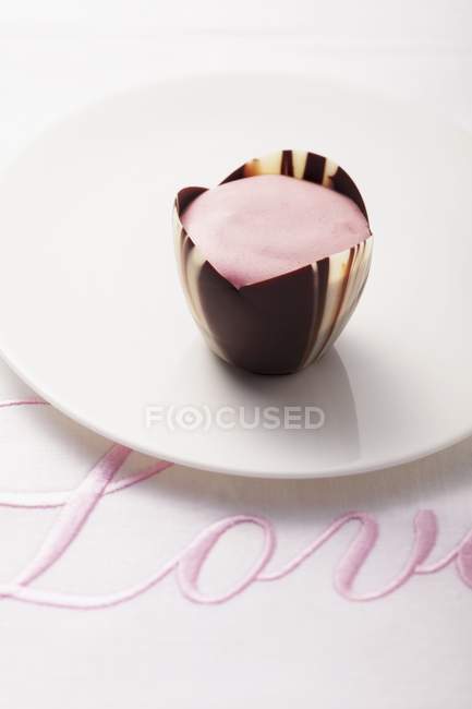 Vista close-up de rosa Praline em pano bordado com a palavra Amor — Fotografia de Stock
