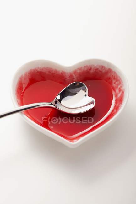 Vista elevata di una ciotola a forma di cuore con un cucchiaio a forma di cuore — Foto stock
