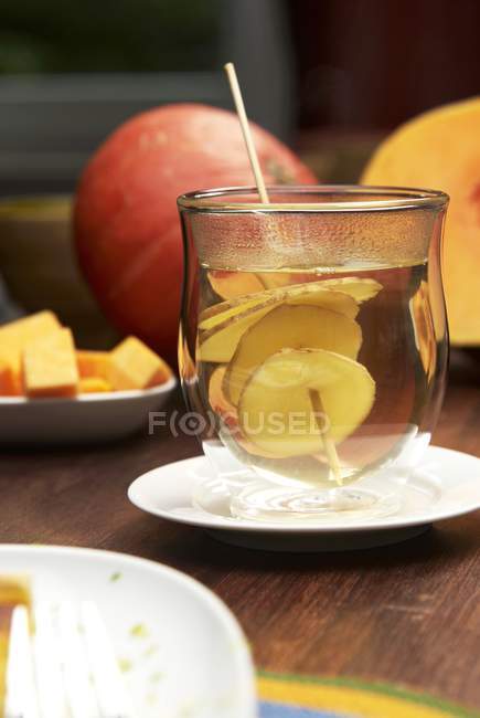Agua caliente de jengibre en vidrio sobre la mesa - foto de stock