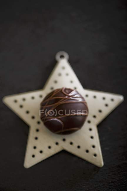 Chocolate praline on Christmas star — Stock Photo