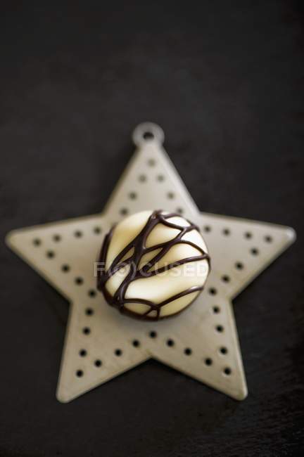 Chocolate praline on Christmas star — Stock Photo