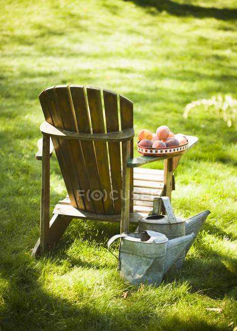 Daytime view of wooden chair with peaches on the arm — Stock Photo