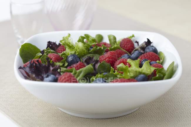 Closeup view of organic salad of mixed greens, raspberries and blueberries — Stock Photo