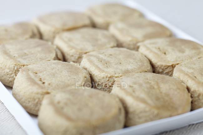 Vue rapprochée des morceaux de pâte à biscuits crus sur le plateau d'emballage — Photo de stock