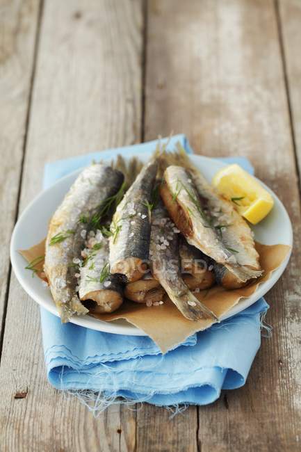 Closeup view of fried herring with salt and lemon — Stock Photo