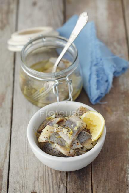 Preserved herrings in oil with lemons — Stock Photo