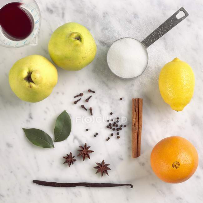 Closeup view of quince with cinnamon, orange, lemon, sugar, vanilla, clove, anise stars, bay leaves and red wine — Stock Photo
