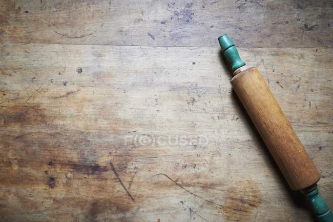 Vista superior de un rodillo sobre una superficie de madera - foto de stock