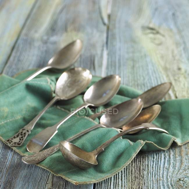 Closeup view of assorted silver spoons on felt cloth — Stock Photo
