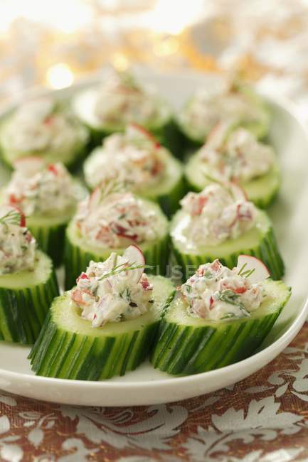 Cucumber slices filled with quark, radishes and herbs  on white plate — Stock Photo
