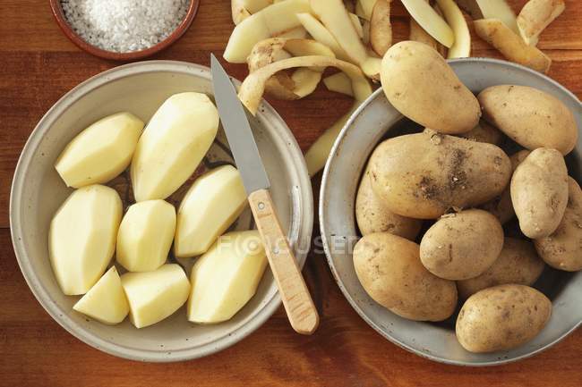 Peeled and unpeeled Potatoes — Stock Photo