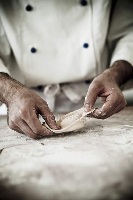 Cocinero haciendo pasta fresca de tortellini - foto de stock