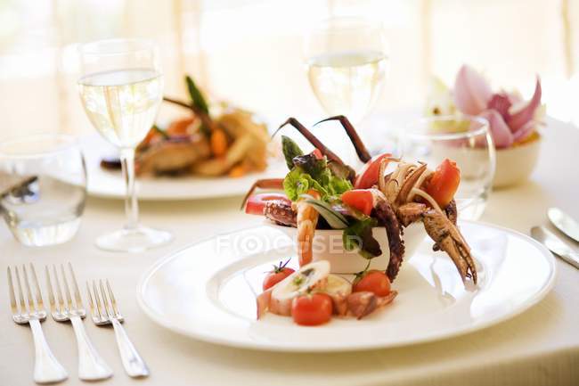 Salat mit Krake und Krabbe auf weißem Teller über Tisch — Stockfoto
