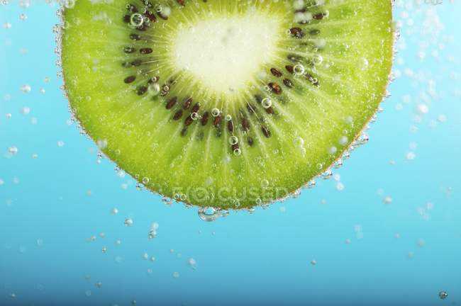 Kiwi-Scheibe in Wasser — Stockfoto