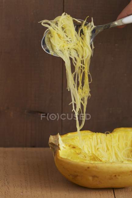 Spaghetti squash on spoon over wooden background — Stock Photo