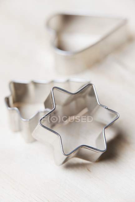 Closeup view of three cookie cutters on wooden surface — Stock Photo
