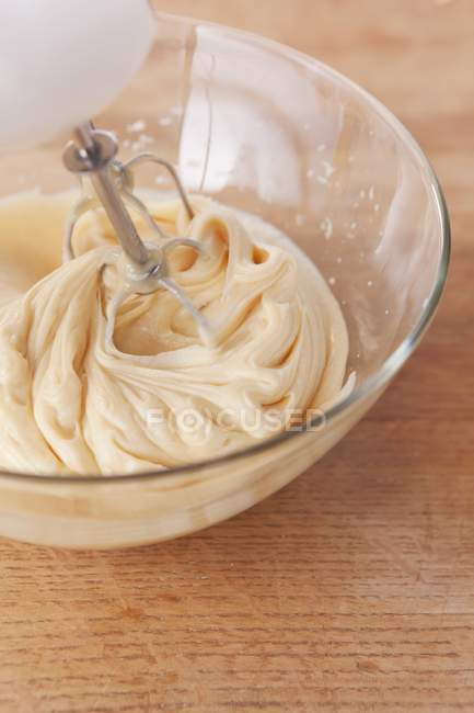 Vista close-up de mistura de bolo em tigela de vidro com misturador — Fotografia de Stock