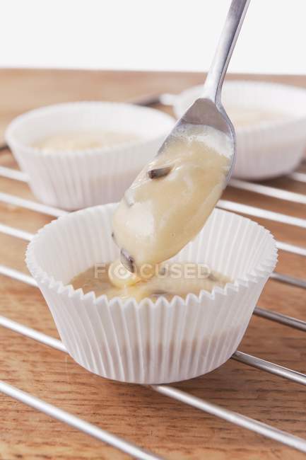 Mistura de muffin sendo colocado em caixas de papel — Fotografia de Stock