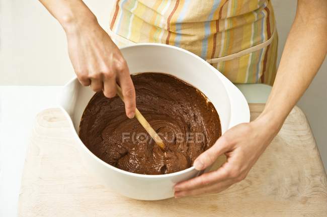 Woman stirring chocolate cake mixture — Stock Photo
