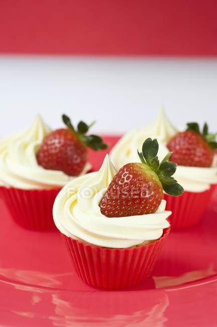 Three cupcakes with vanilla icing — Stock Photo