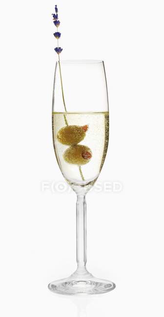Ein Glas Prosecco mit zwei Oliven auf weißem Hintergrund — Stockfoto