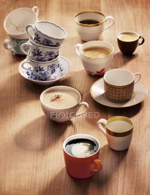 Vista de cerca de una variedad de tazas de café y variedades de café - foto de stock