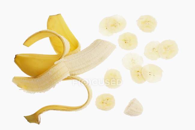 Banana meio descascada e fatias — Fotografia de Stock