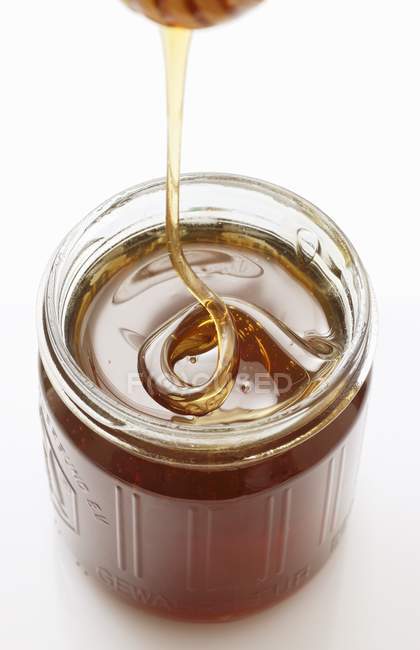 Honey trickling from dipper — Stock Photo