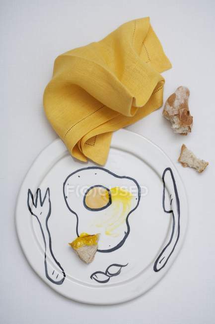 Top view of a still life with smears of egg yolk and bread — Stock Photo