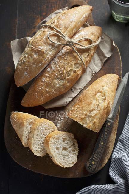 Whole and sliced baguette rolls — Stock Photo