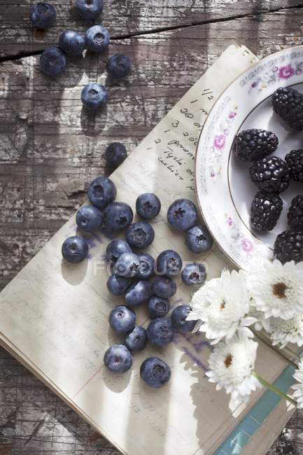Blueberries and blackberries with flowers — Stock Photo