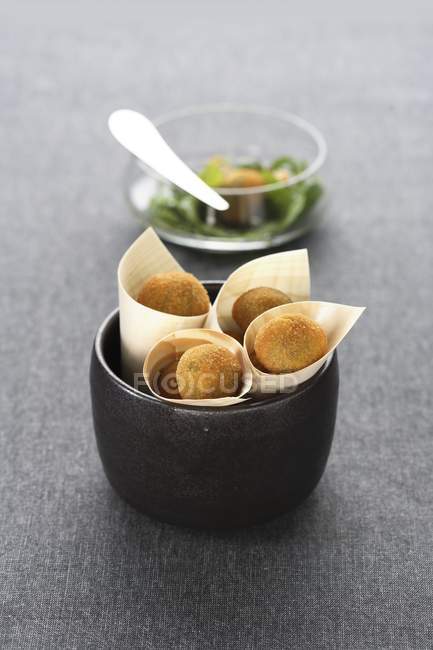 Оливковая фритта - оливки в коричневой миске с хлебом и жареными оливками на серой поверхности — стоковое фото