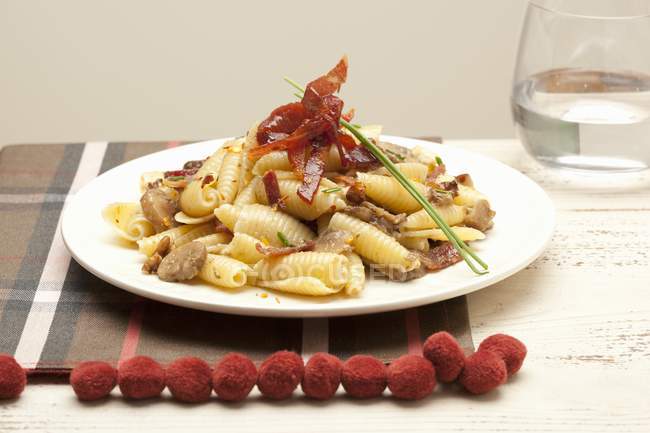 Conchiglie pasta with mushrooms and ham — Stock Photo