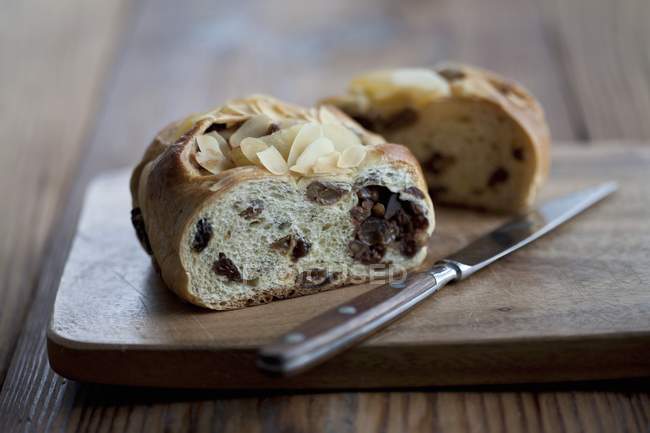 Hefezopf - солодкий хліб з інжиром та родзинками на дерев'яному столі з ножем — стокове фото